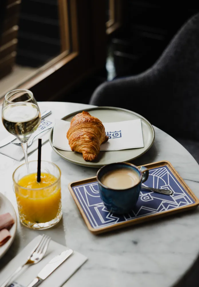 Breakfast with a croissant, coffee and orange juice