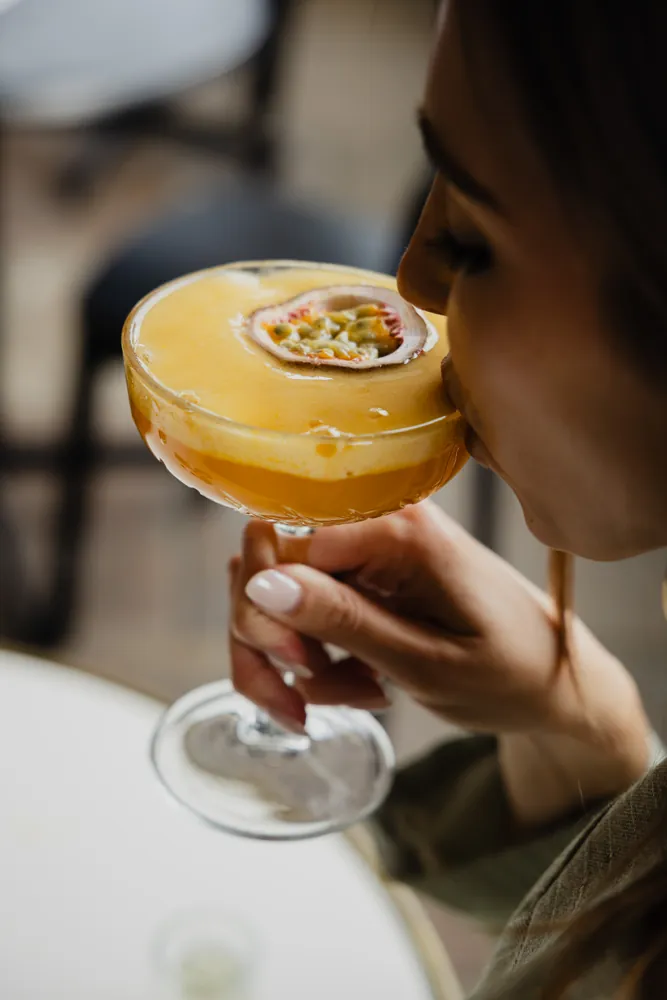 A guest sipping a passion fruit cocktail