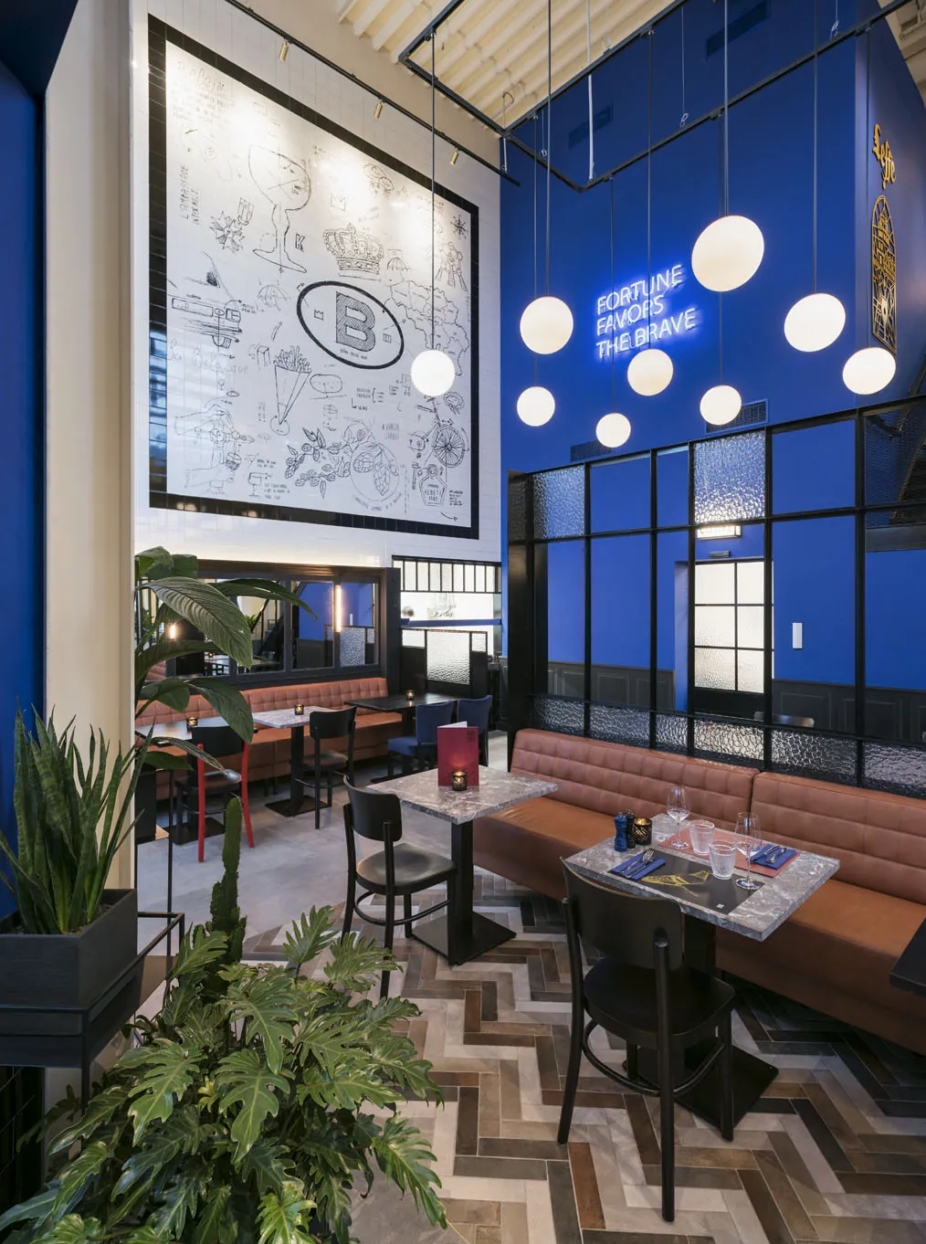 The blue wall, globe lights and banquettes at Le Petit Belge Maasmechelen Village