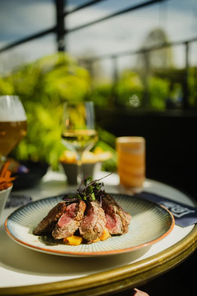 Sliced steak with a beer on the side